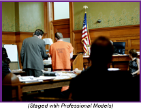Man in orange jumpsuit with his lawyer in a courtroom (Staged with Professional Models).